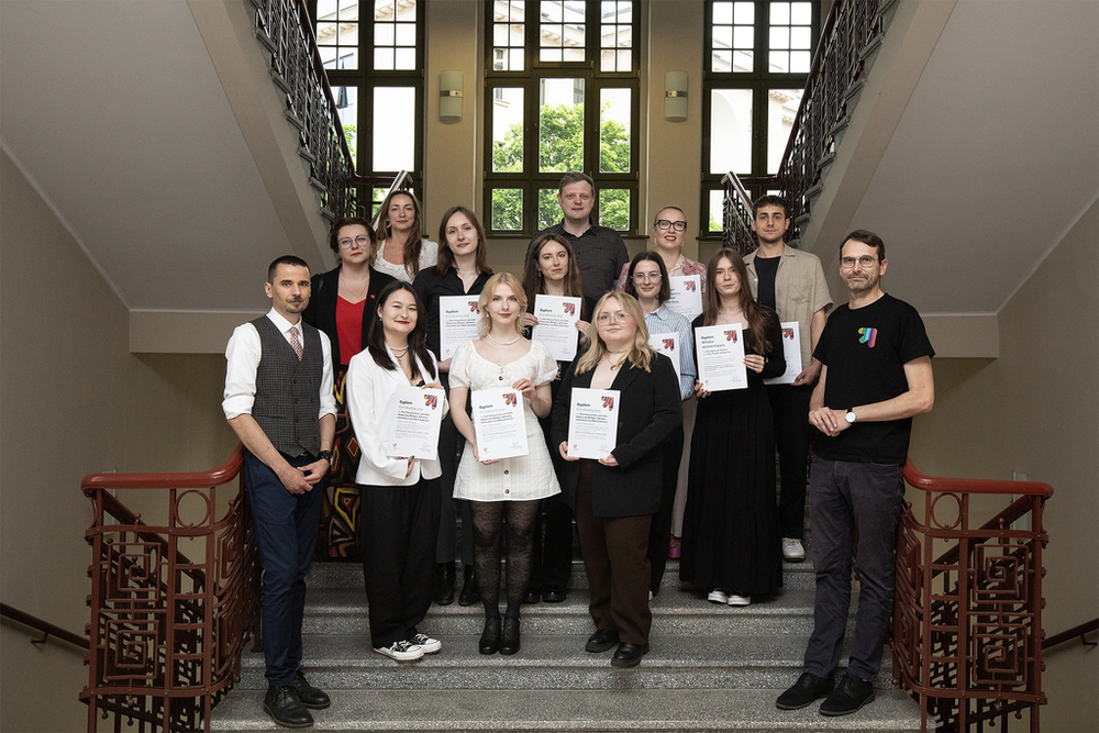 Zdjęcie grupowe osób nagrodzonych w konkursie w raz z Rektorem i jury konkursu wykonane na schodach głównej klatki schodowej Rektoratu Uniwersytetu Łódzkiego